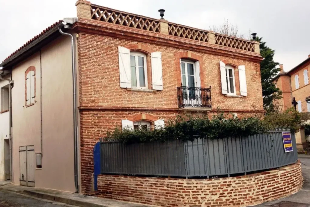 Ravalement de façade sur une maison traditionnelle en brique rose typique du centre de Toulouse.